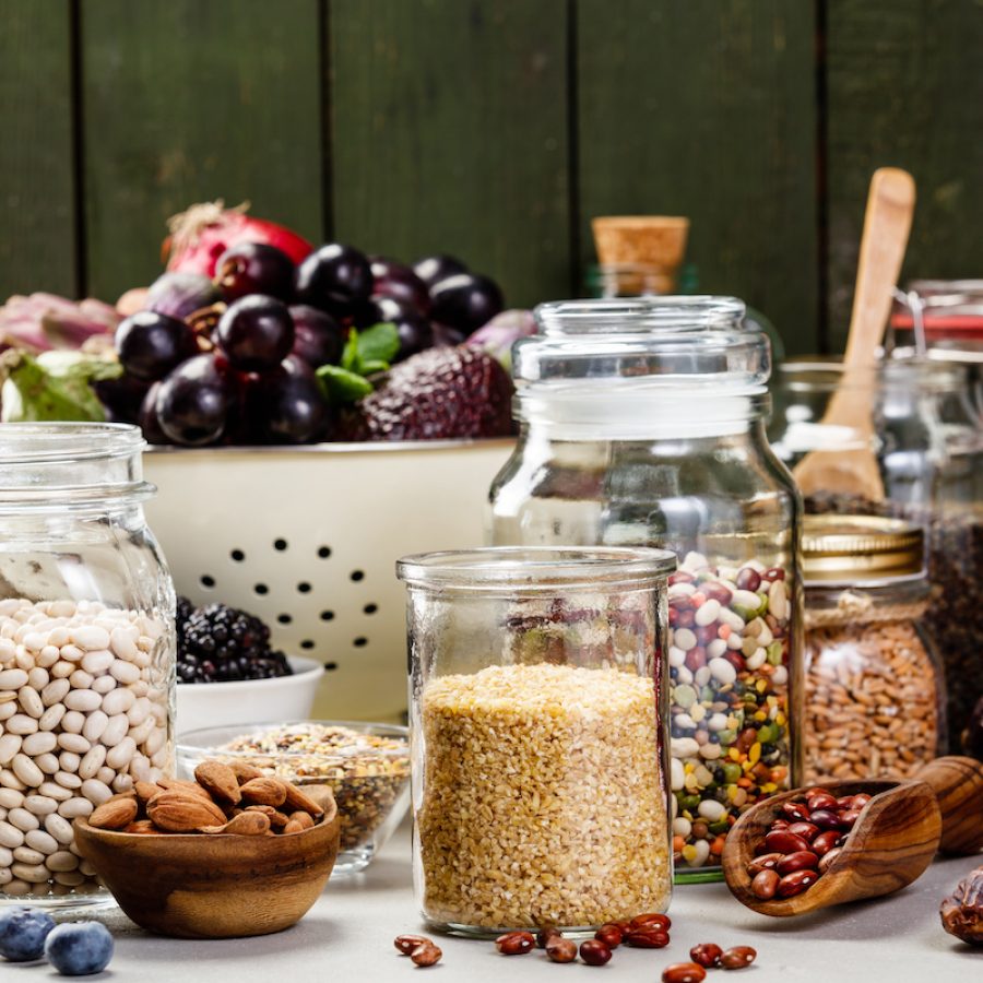 Balanced diet, cooking, vegetarian, raw and clean eating concept - close up of fresh organic fruits and vegetables, grains, legumes and nuts on concrete background with space for text